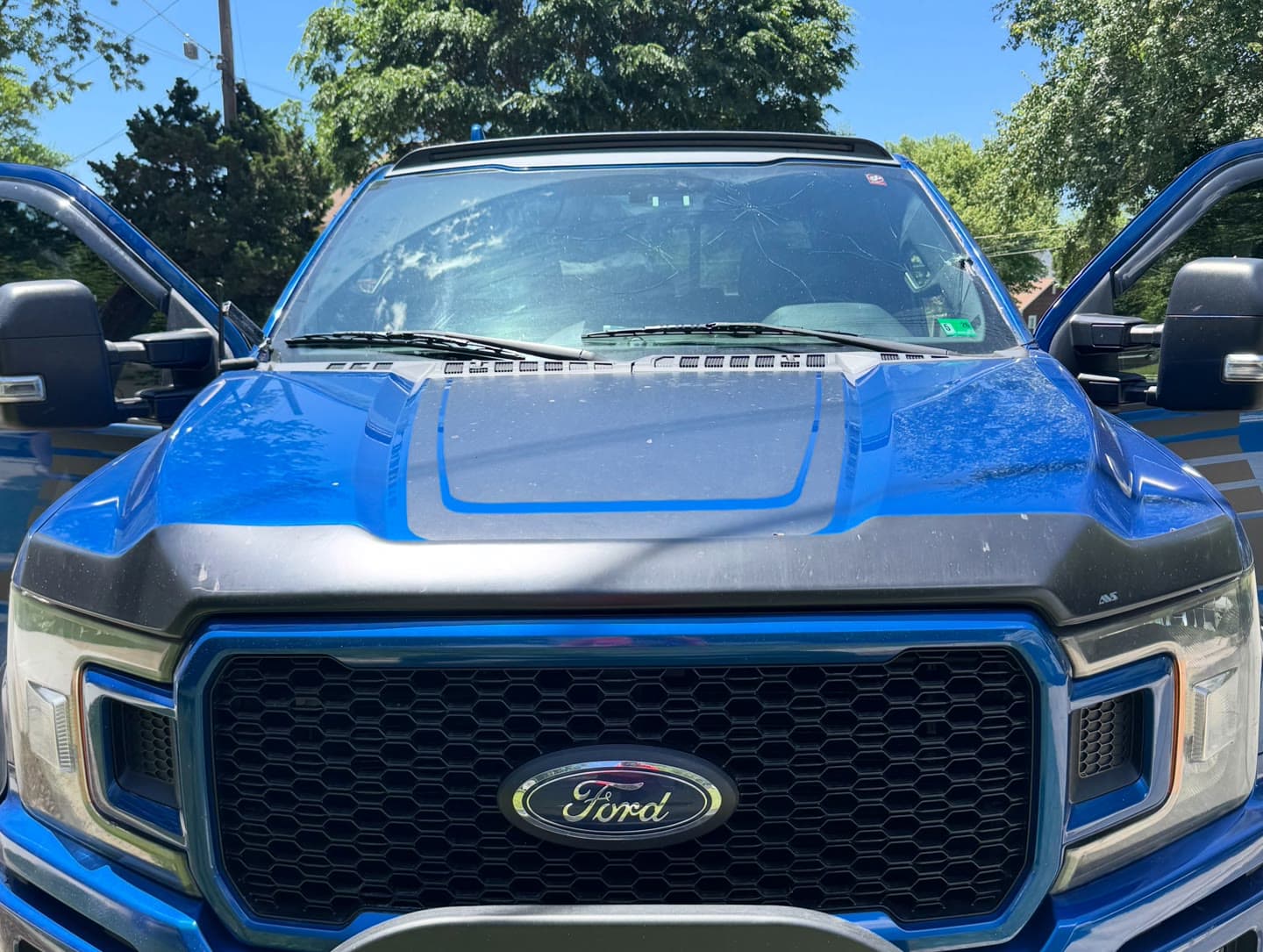 Windshield replacement on a blue Ford F-150, old glass out and OEM-quality glass installed